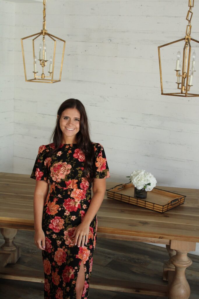 Image of Sarah Lynn Quick Owner leaning against table in professional photo shoot